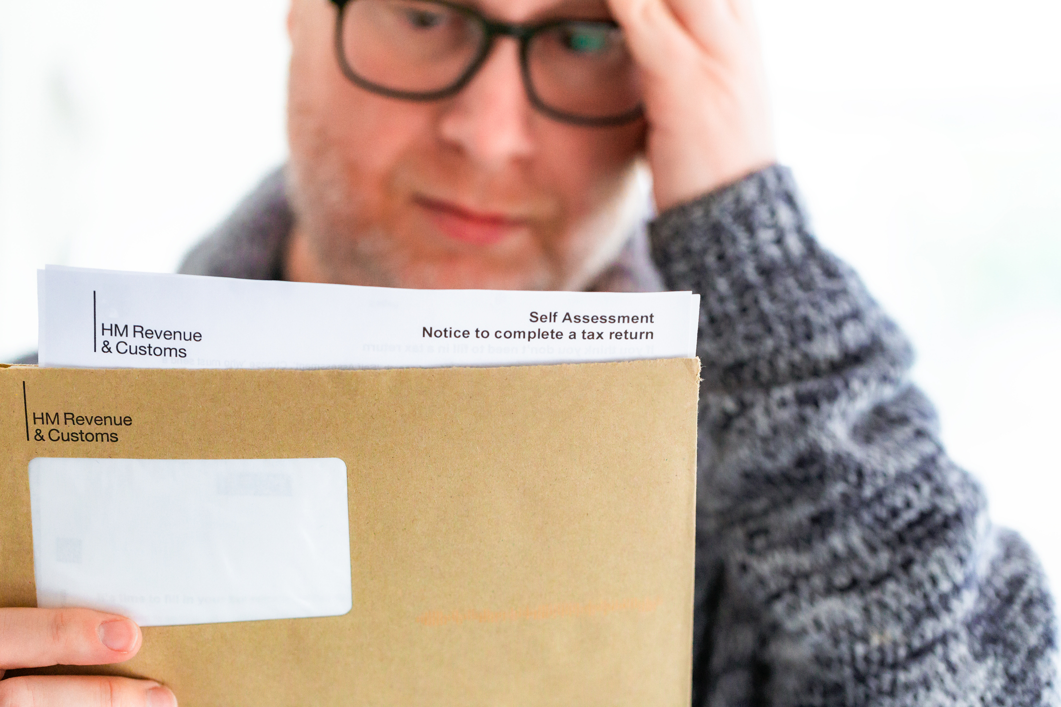 Worried man opening HMRC tax letter